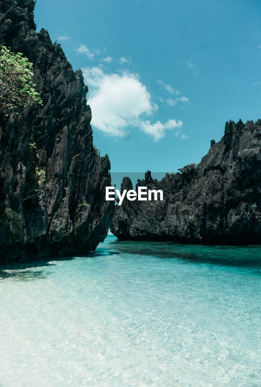 water, sea, scenics - nature, beauty in nature, sky, land, rock, coast, nature, bay, ocean, beach, tranquility, travel destinations, tranquil scene, environment, shore, turquoise colored, travel, blue, lagoon, landscape, idyllic, no people, cloud, body of water, rock formation, island, mountain, outdoors, islet, tourism, non-urban scene, holiday, coastline, trip, terrain, vacation, cliff, day, seascape, tree, tropical climate, bay of water, geology
