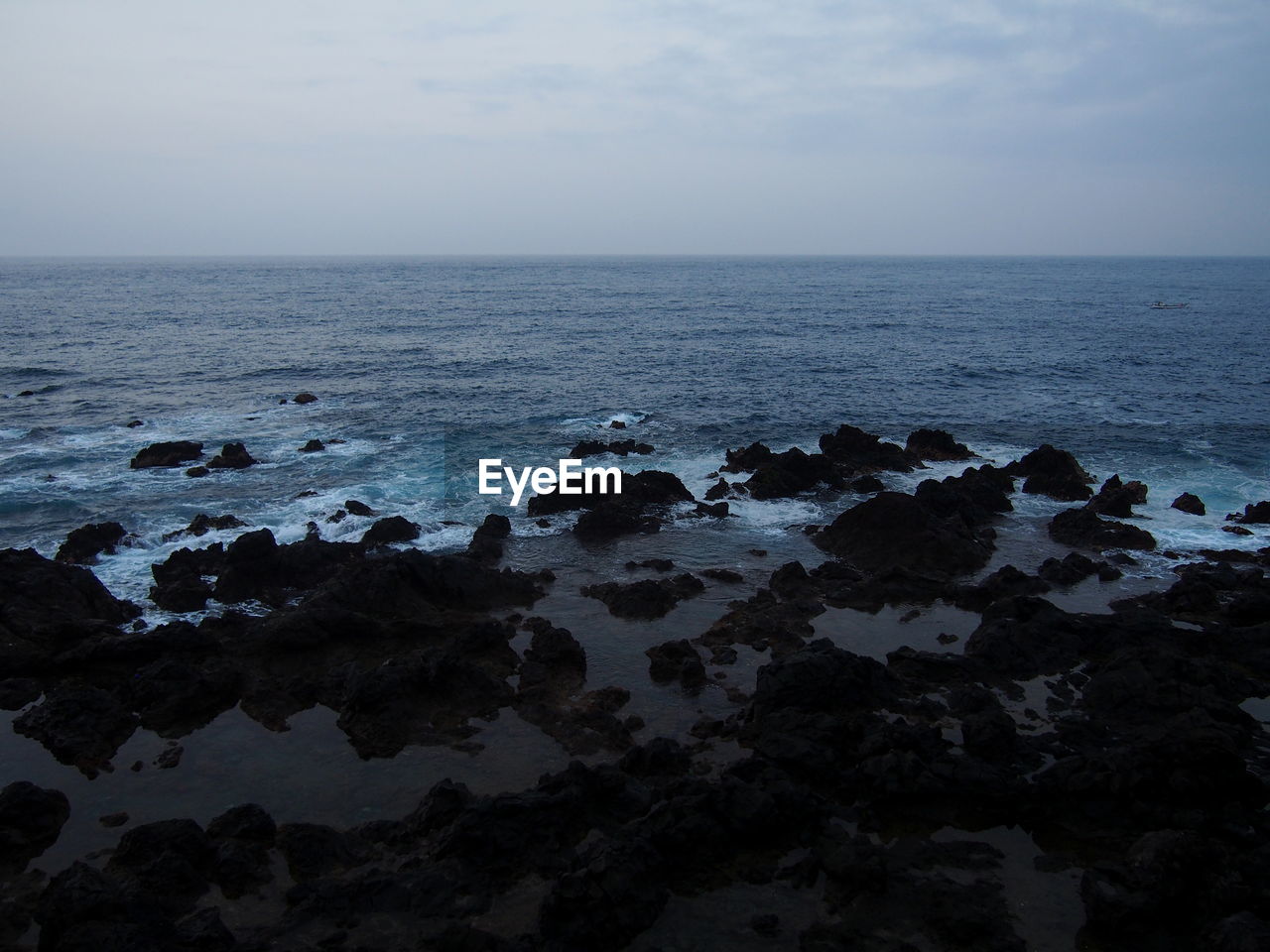 SCENIC VIEW OF ROCKS AT SEA AGAINST SKY