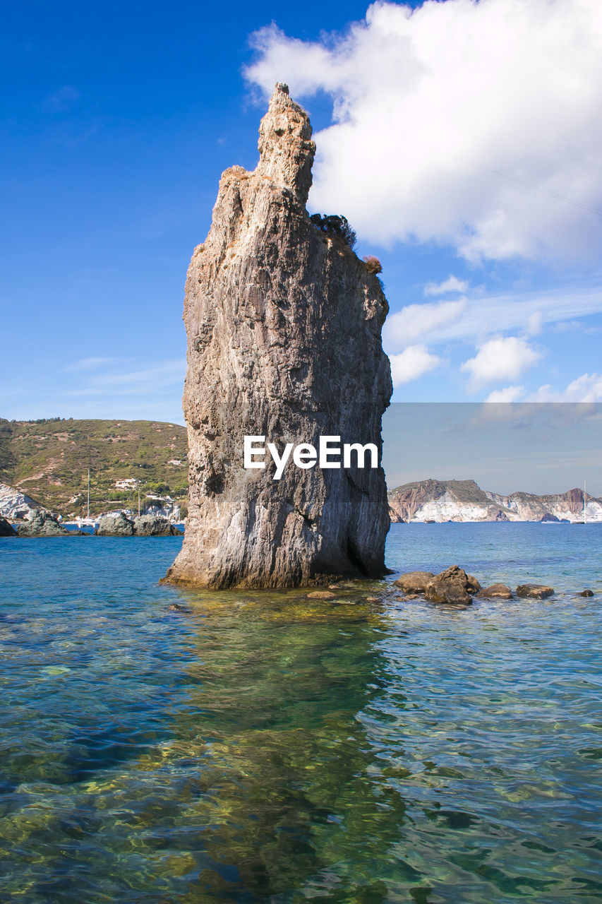 Rock formation in sea against sky