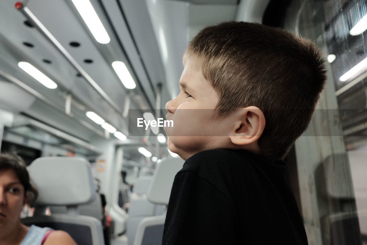 Side view of cute boy sitting in bus