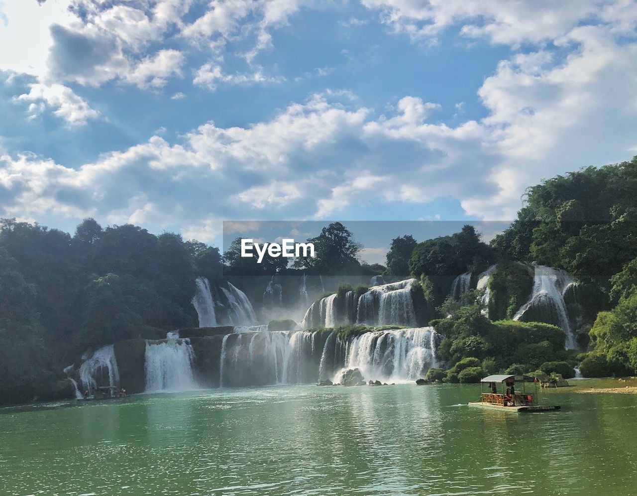 water, waterfall, scenics - nature, beauty in nature, nature, environment, tree, travel, travel destinations, body of water, sky, tourism, plant, motion, cloud, landscape, water feature, trip, vacation, river, holiday, outdoors, tropical climate, forest, land, tourist, nautical vessel, mountain, day, rock, long exposure, environmental conservation, non-urban scene, transportation, adventure, idyllic