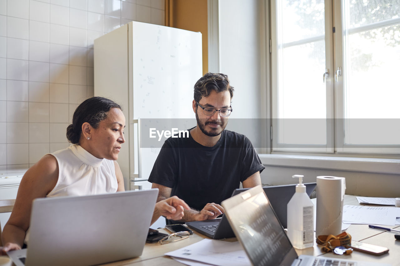 Woman and man using laptops