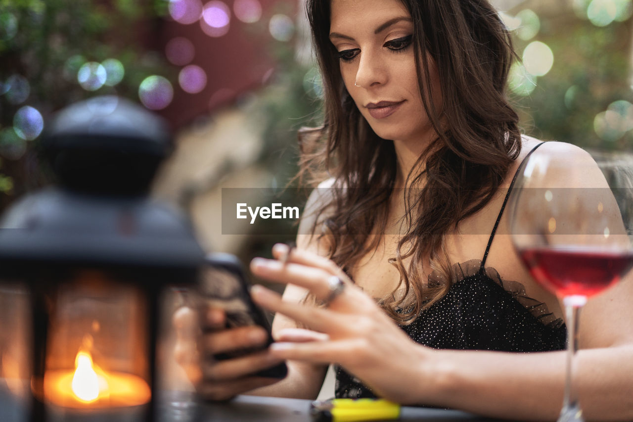 Beautiful woman using mobile phone at table