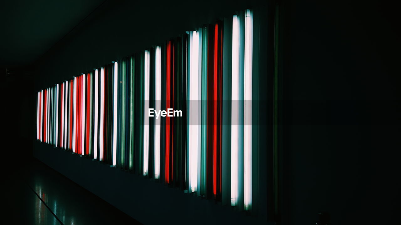 Row of illuminated fluorescent lights in dark