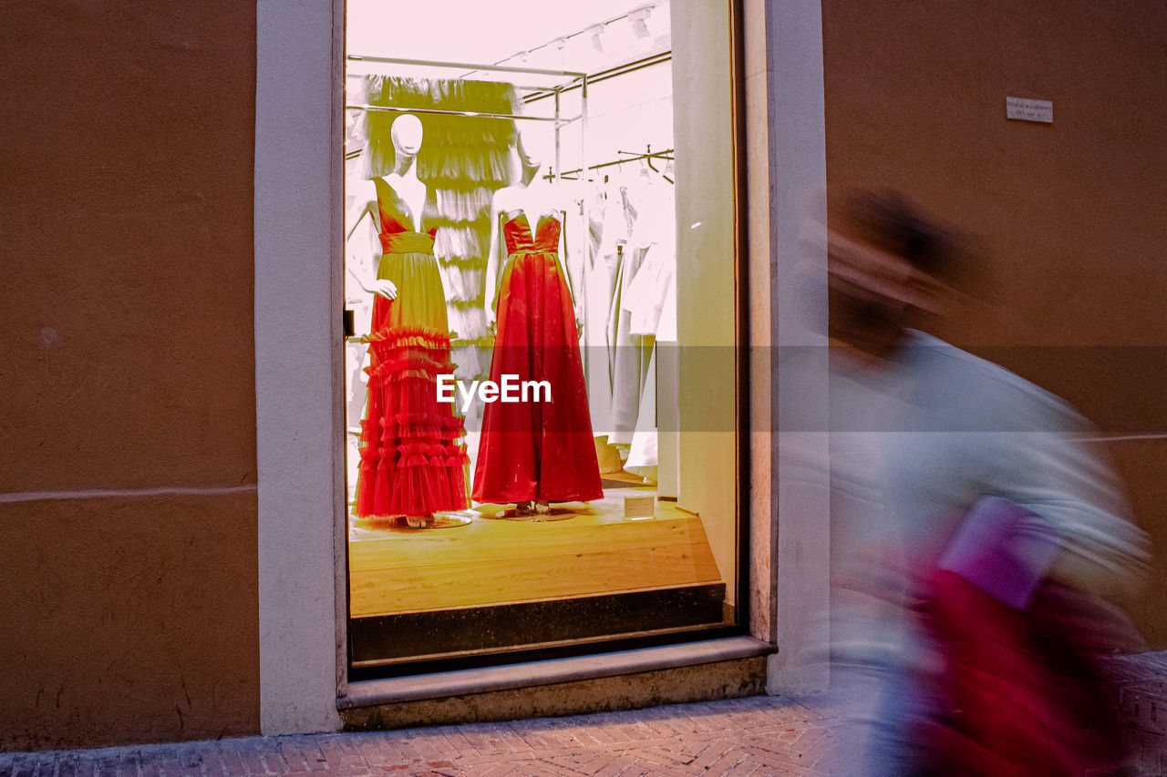 WOMAN WALKING BY WINDOW OF BUILDING