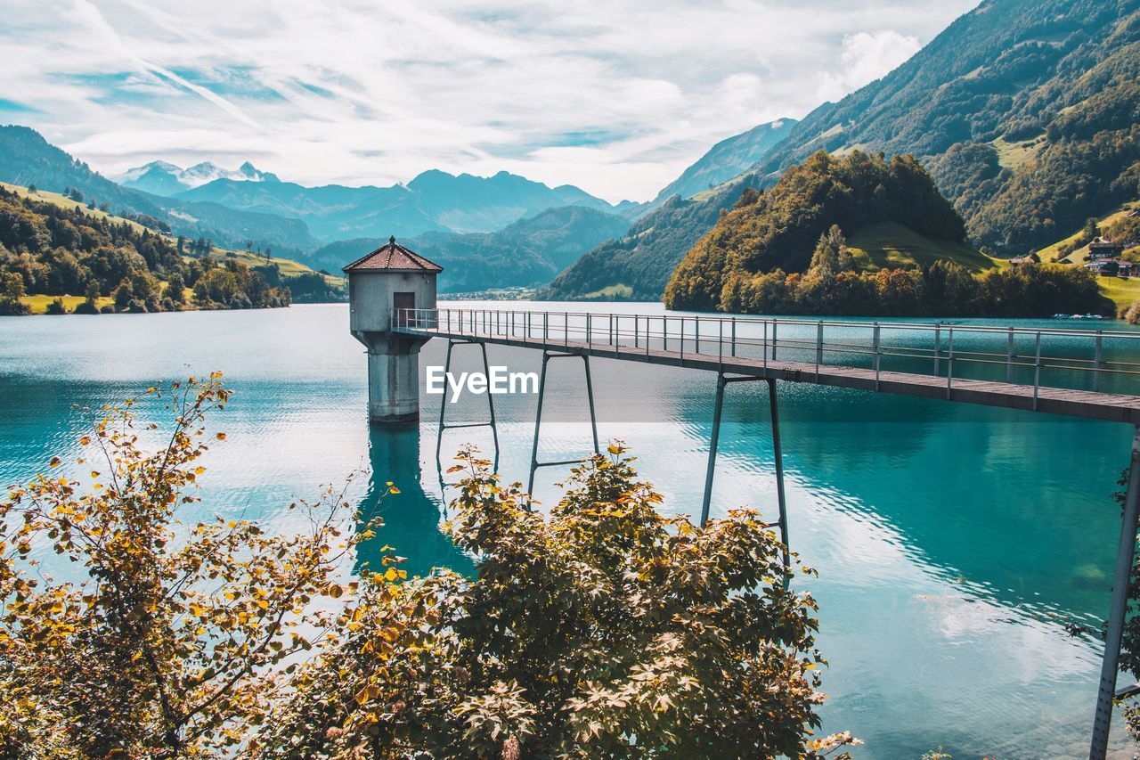 Scenic view of lake by mountains against sky