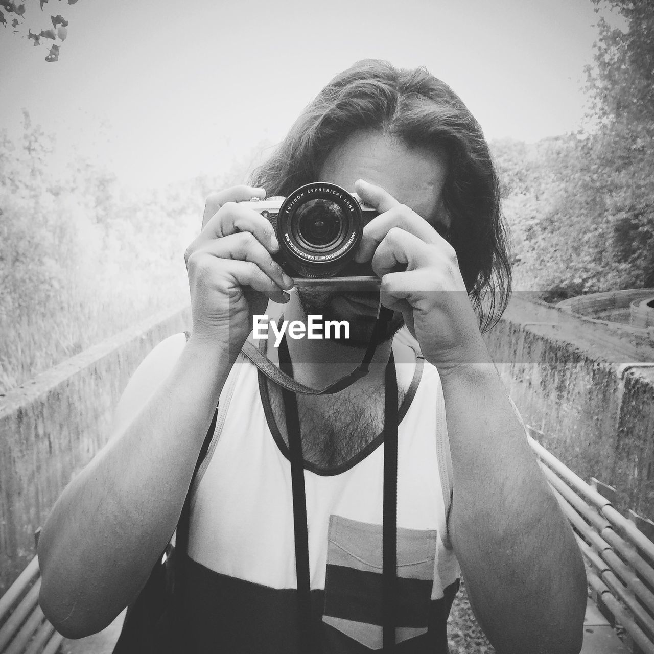 YOUNG WOMAN PHOTOGRAPHING WHILE STANDING ON STEPS