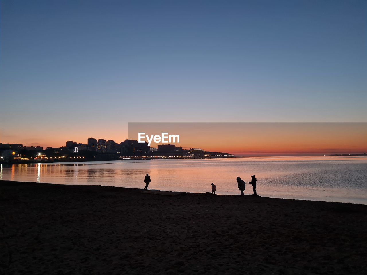 SILHOUETTE PEOPLE ON BEACH AGAINST CLEAR SKY