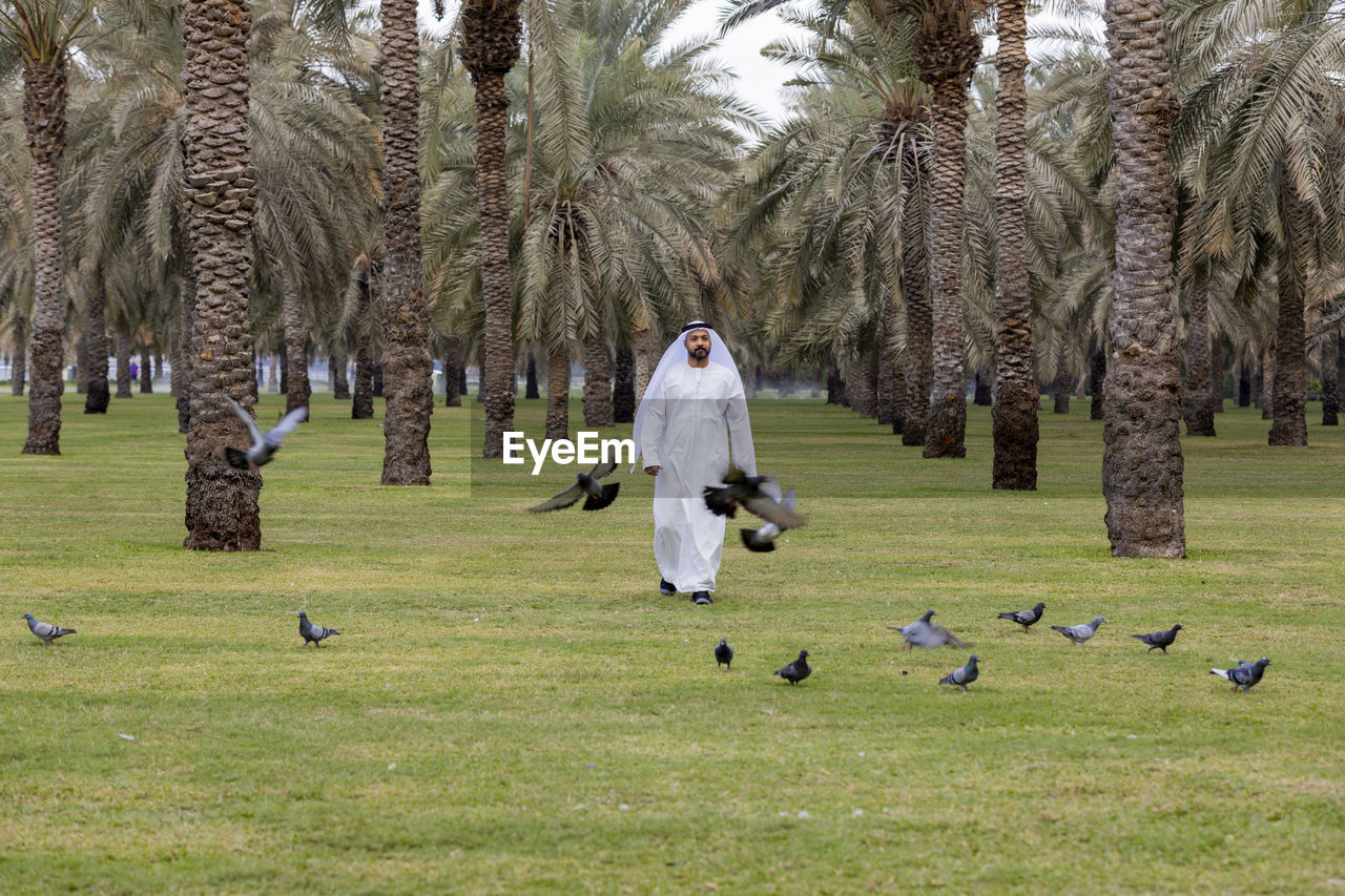 Man wearing traditional clothing walking on land