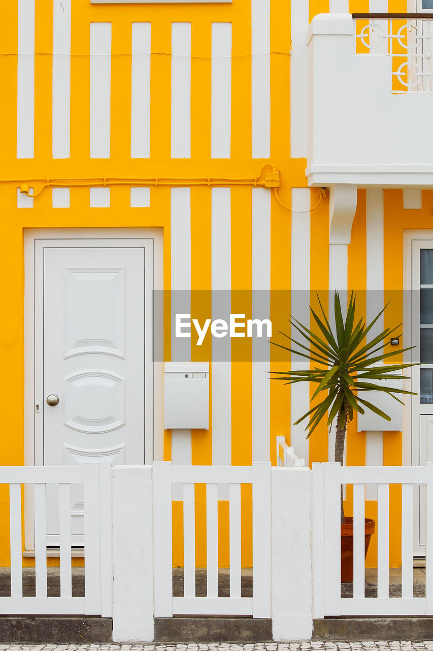 Typical colourful houses with yellow and white stripes in costa nova - aveiro against sky