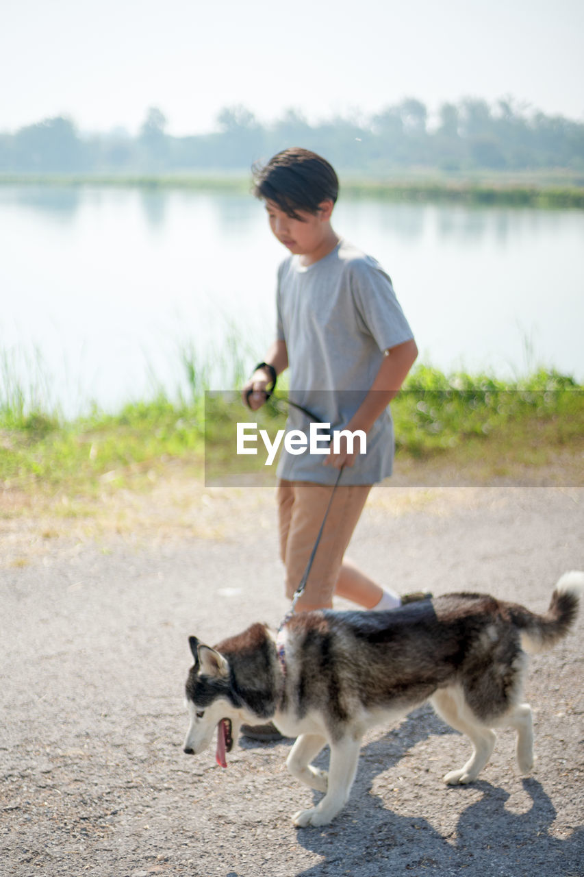 Full length of woman with dog on lake