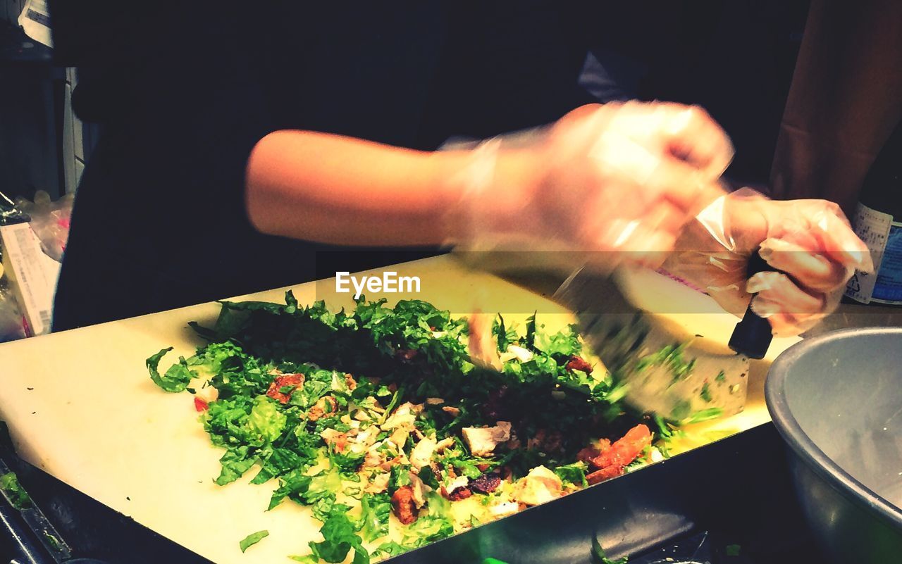 Blurred motion of person preparing salad