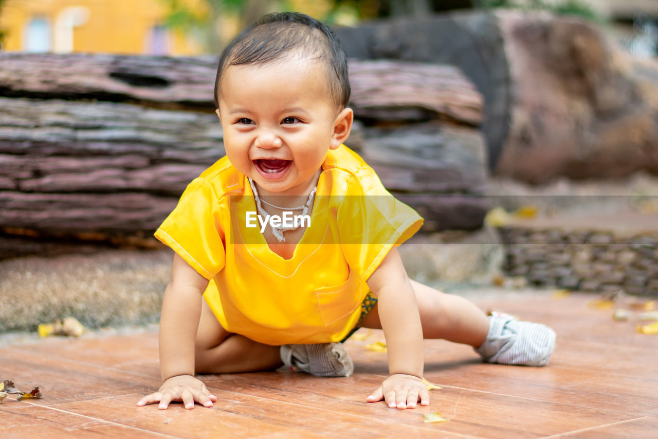 Portrait of the cute boy sitting on the floor