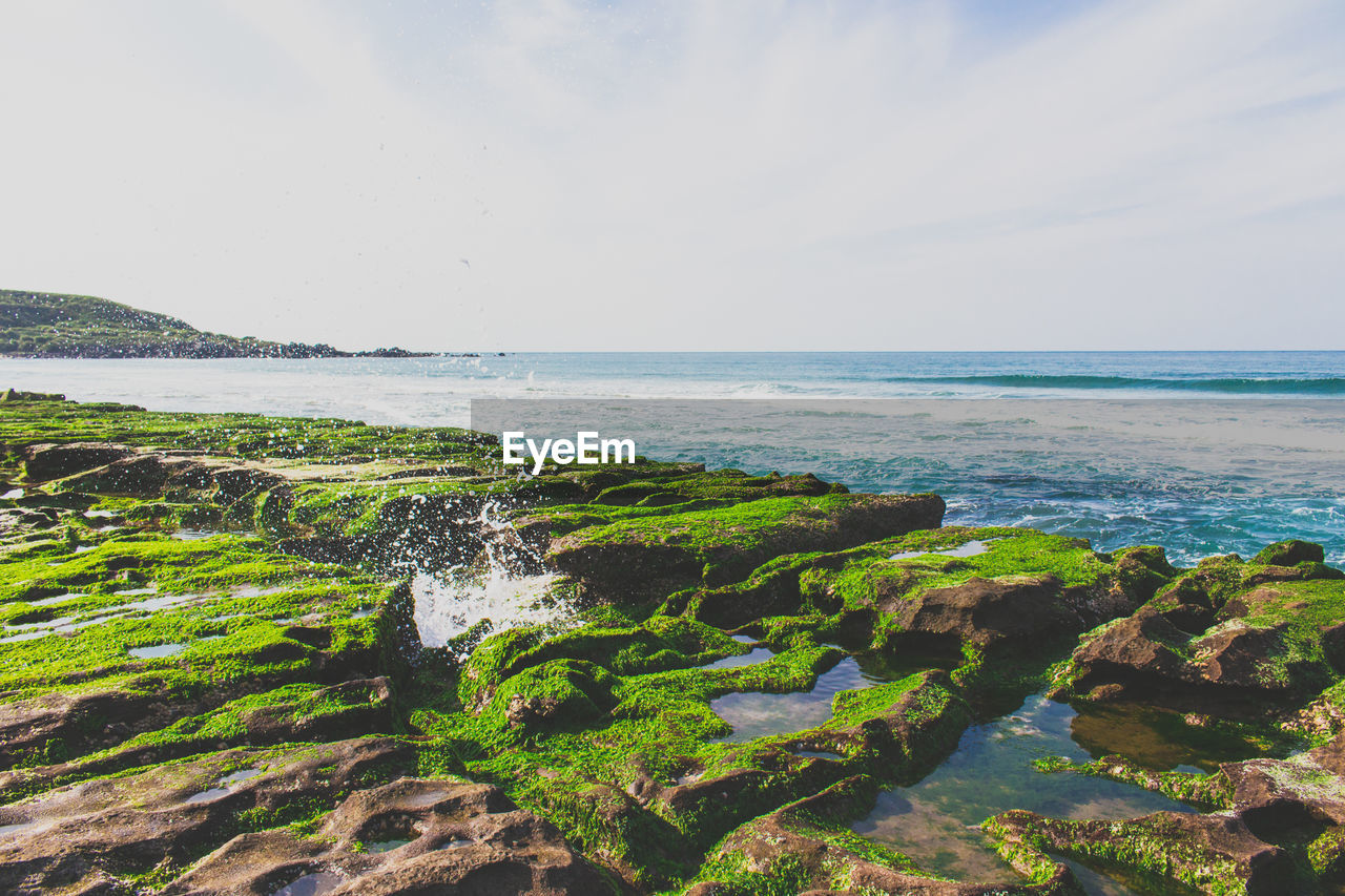 Scenic view of calm sea against cloudy sky