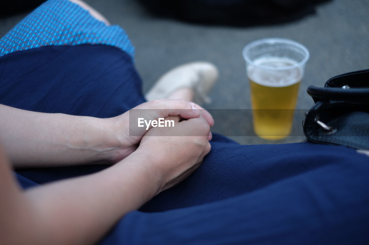 Low section of woman with alcohol in drinking glass