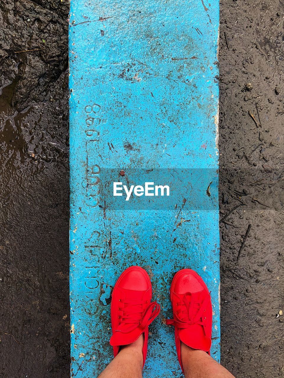 LOW SECTION VIEW OF WOMAN STANDING ON BLUE FLOOR