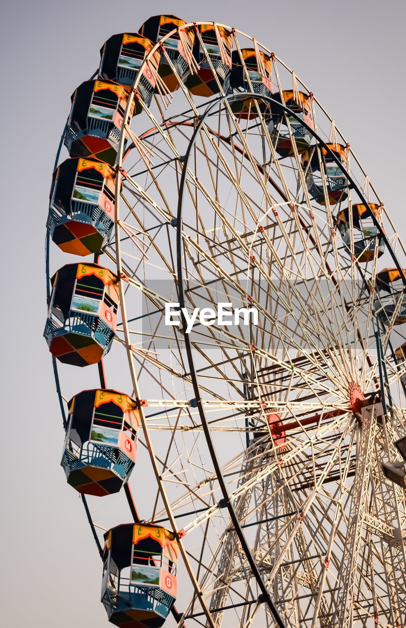 ferris wheel, amusement park ride, amusement park, arts culture and entertainment, leisure activity, sky, carnival, fun, nature, traveling carnival, recreation, geometric shape, circle, low angle view, enjoyment, shape, amber, amusement ride, outdoors, travel destinations, wheel, no people, multi colored, clear sky, park, architecture