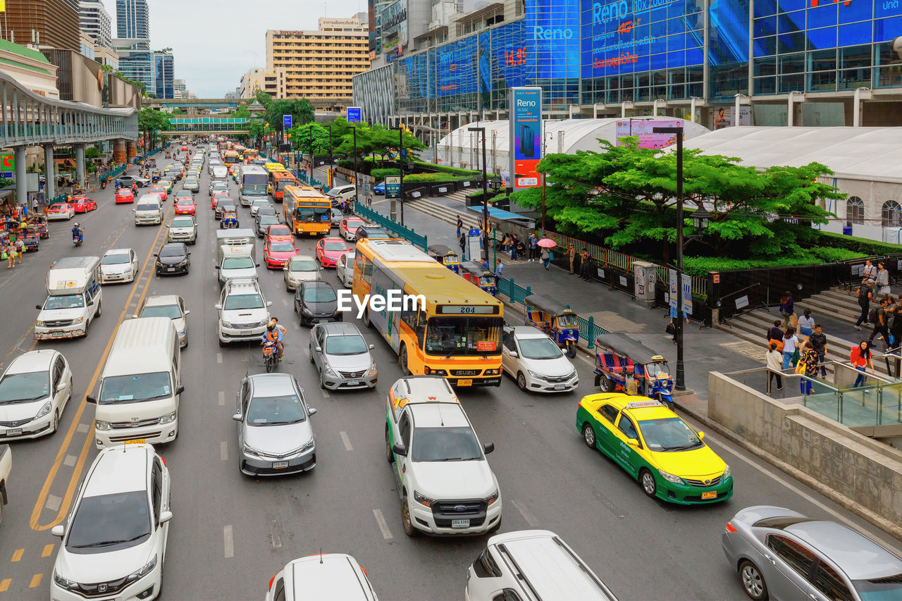 HIGH ANGLE VIEW OF TRAFFIC ON ROAD AMIDST BUILDINGS