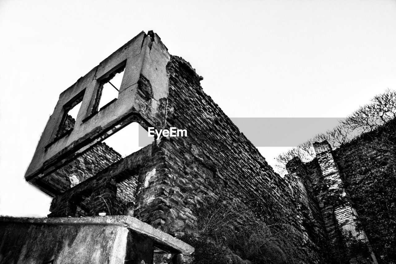 Low angle view of old damaged building against clear sky