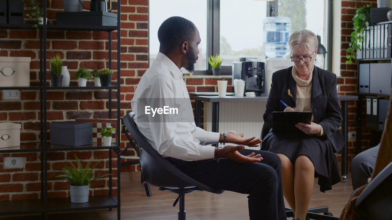 Man talking with psychotherapist in clinic