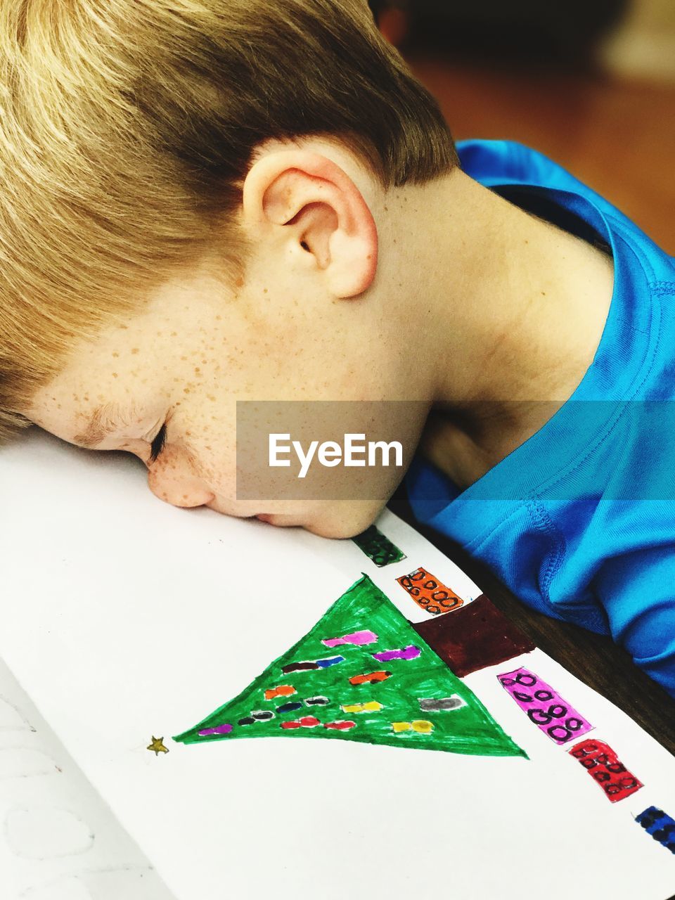 Close-up of boy sleeping on table