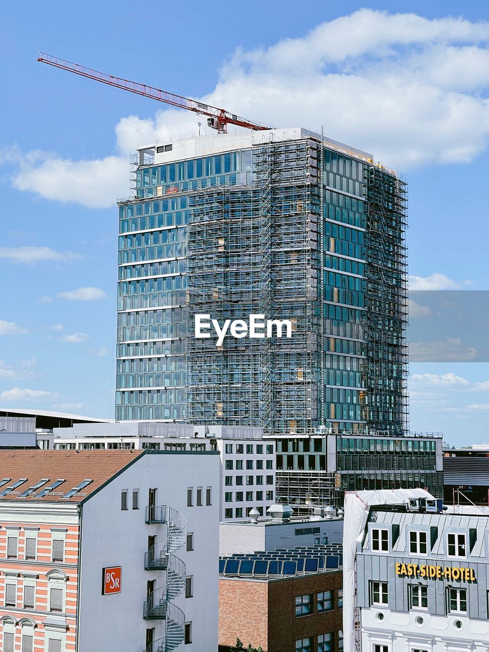 LOW ANGLE VIEW OF CRANE AGAINST BUILDING