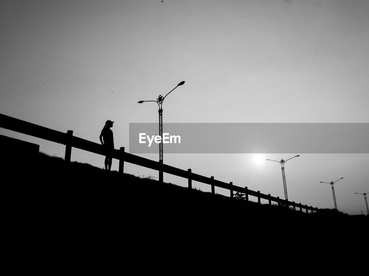 LOW ANGLE VIEW OF SILHOUETTE MAN AND BRIDGE AGAINST SKY