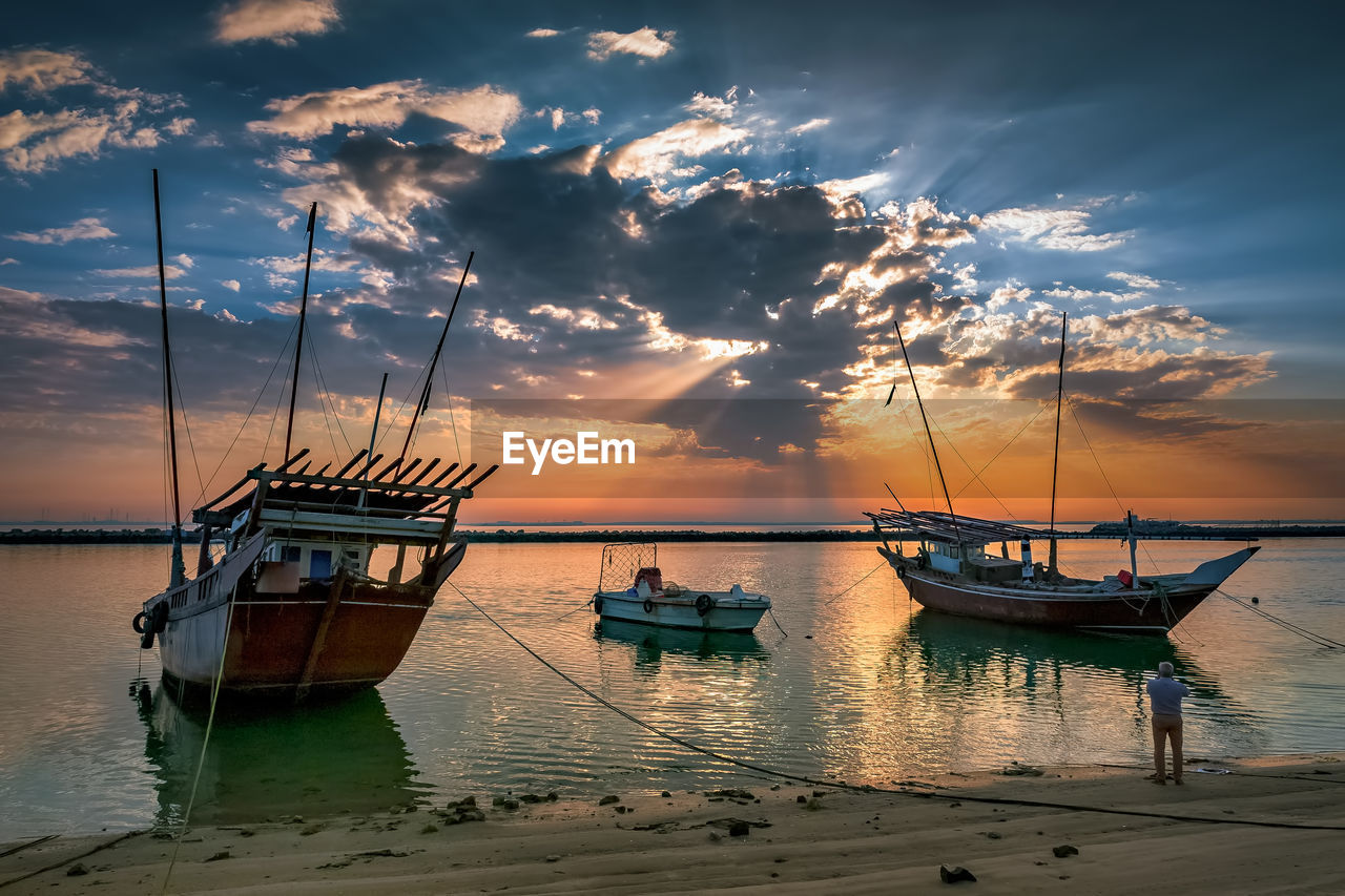 FISHING BOATS IN SEA AGAINST SKY DURING SUNSET