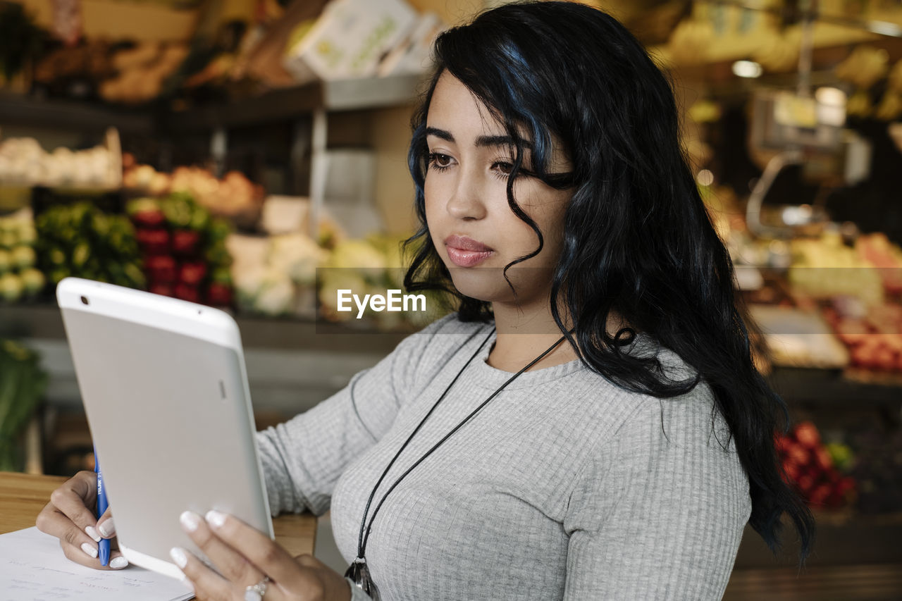 PORTRAIT OF YOUNG WOMAN USING SMART PHONE AT HOME