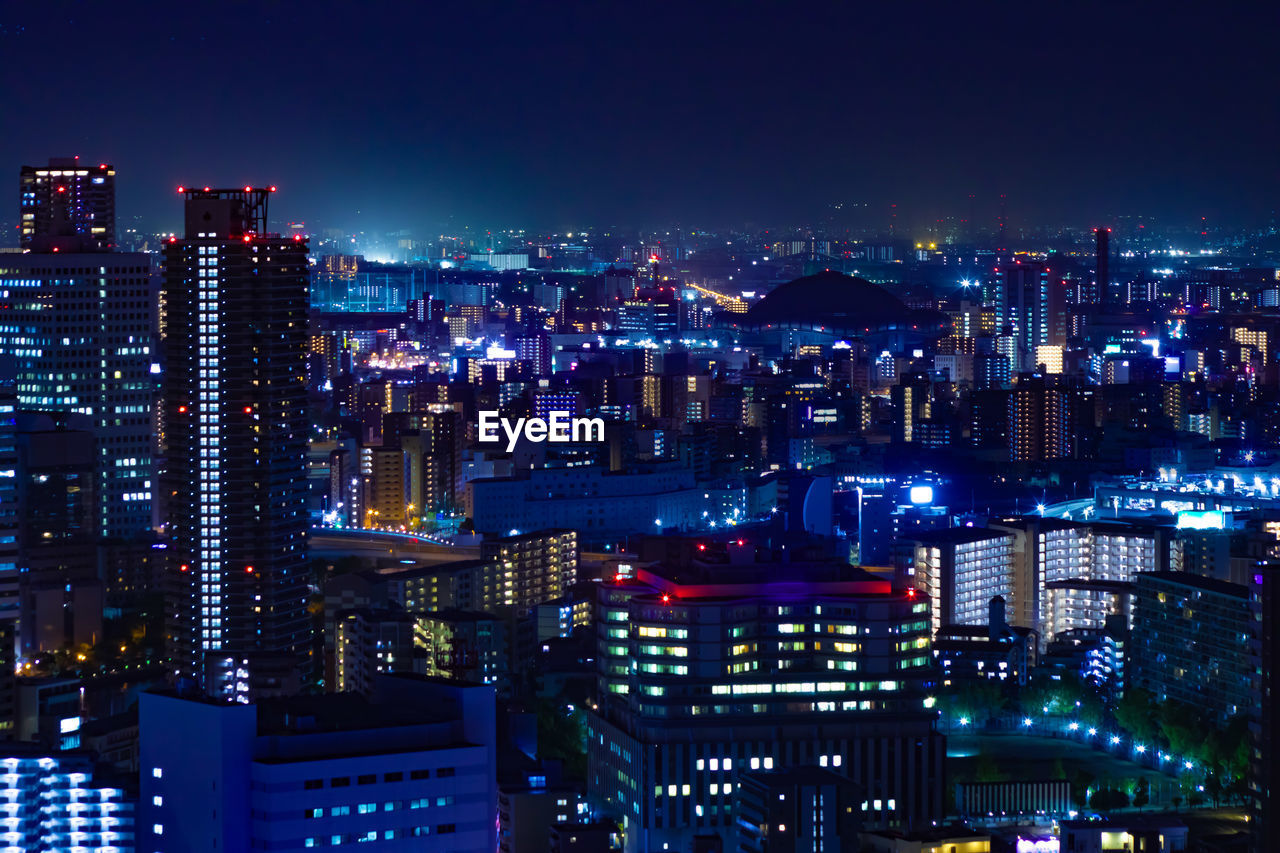 high angle view of illuminated buildings in city at night