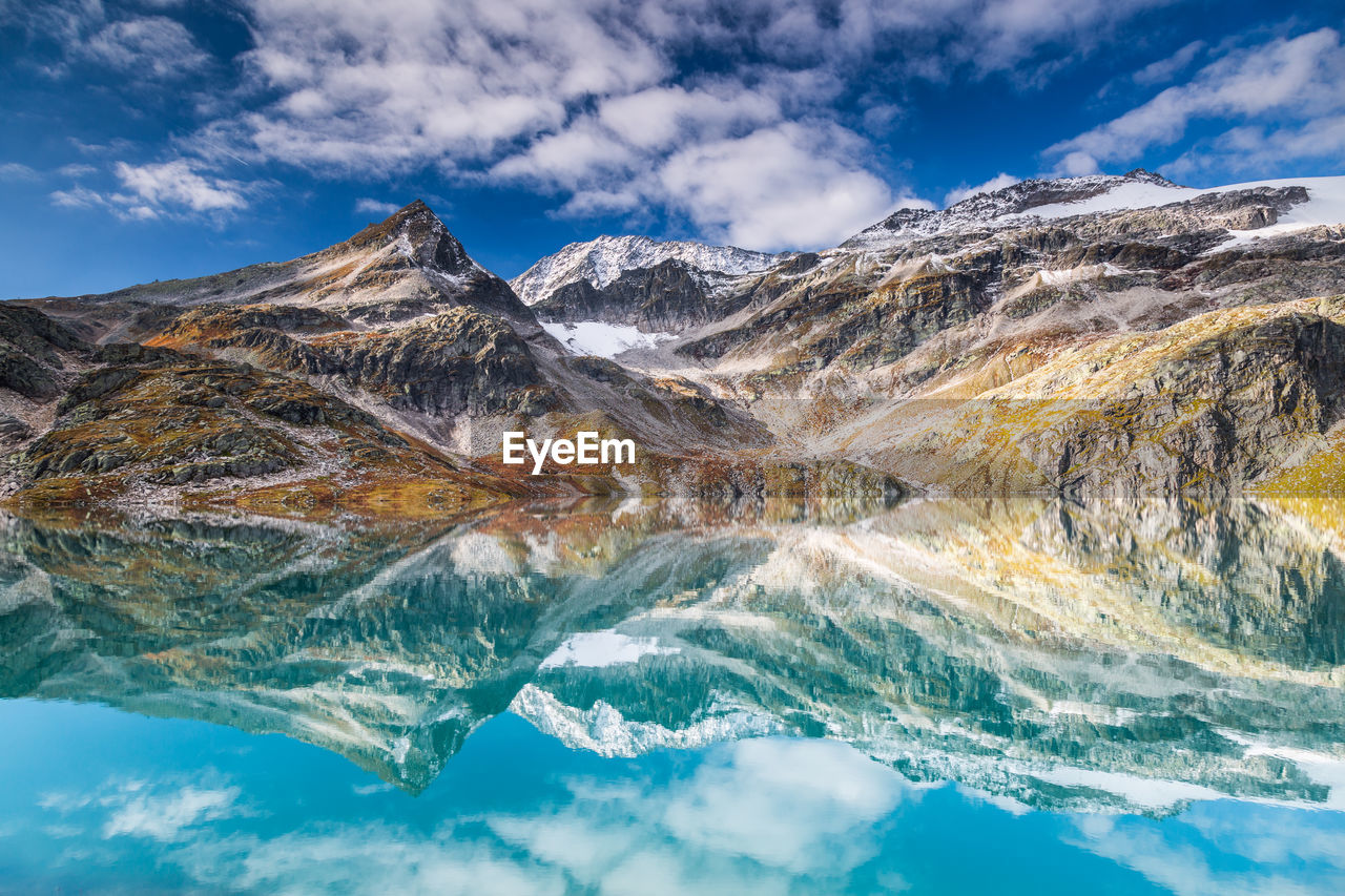 AERIAL VIEW OF SNOWCAPPED MOUNTAINS AGAINST SKY