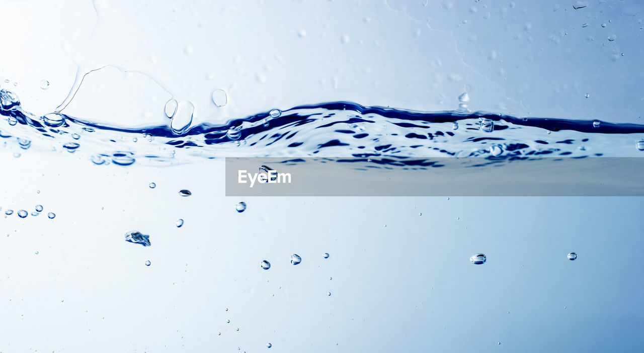 Close-up of water splashing against blue background