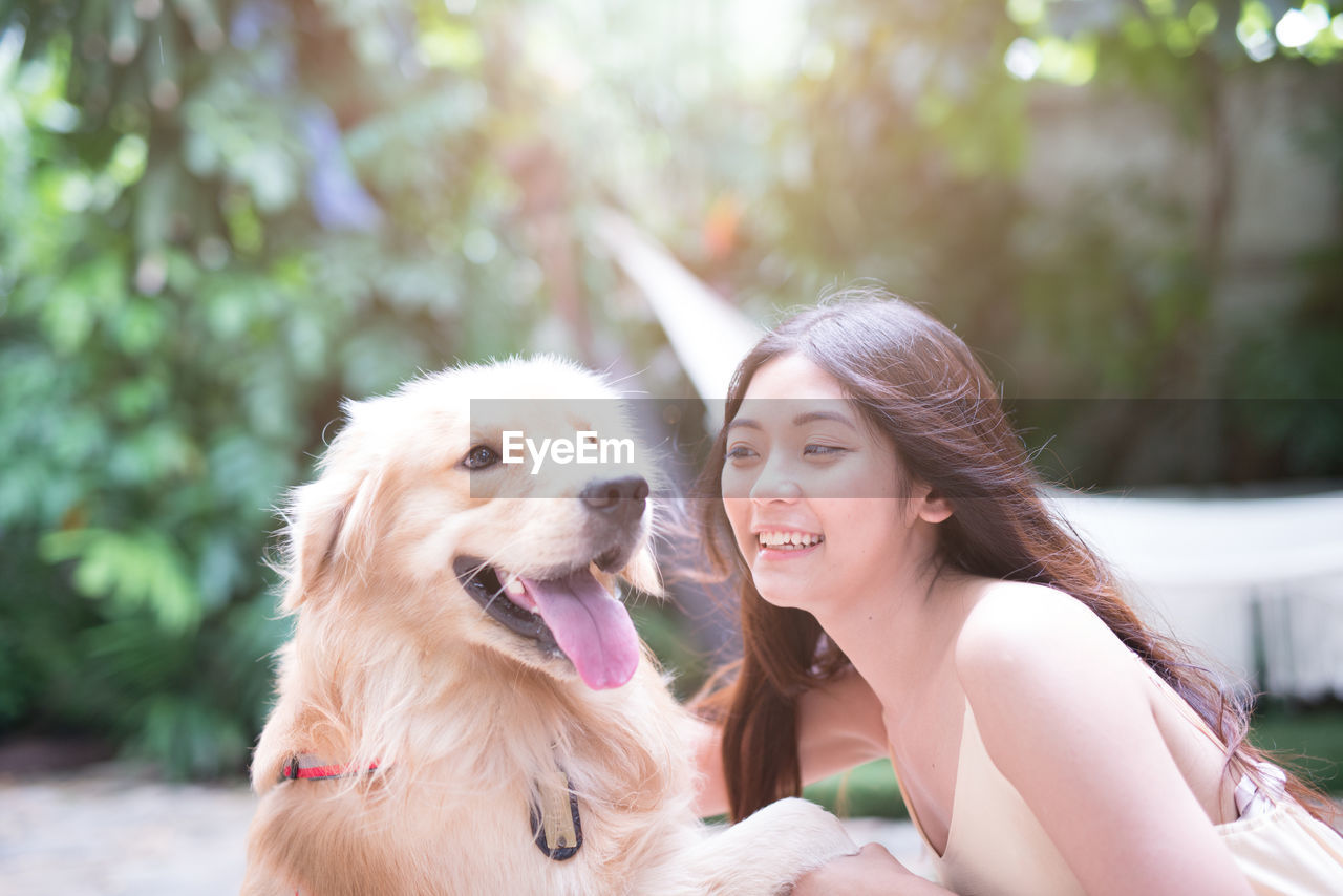 Young woman playing with dog at park