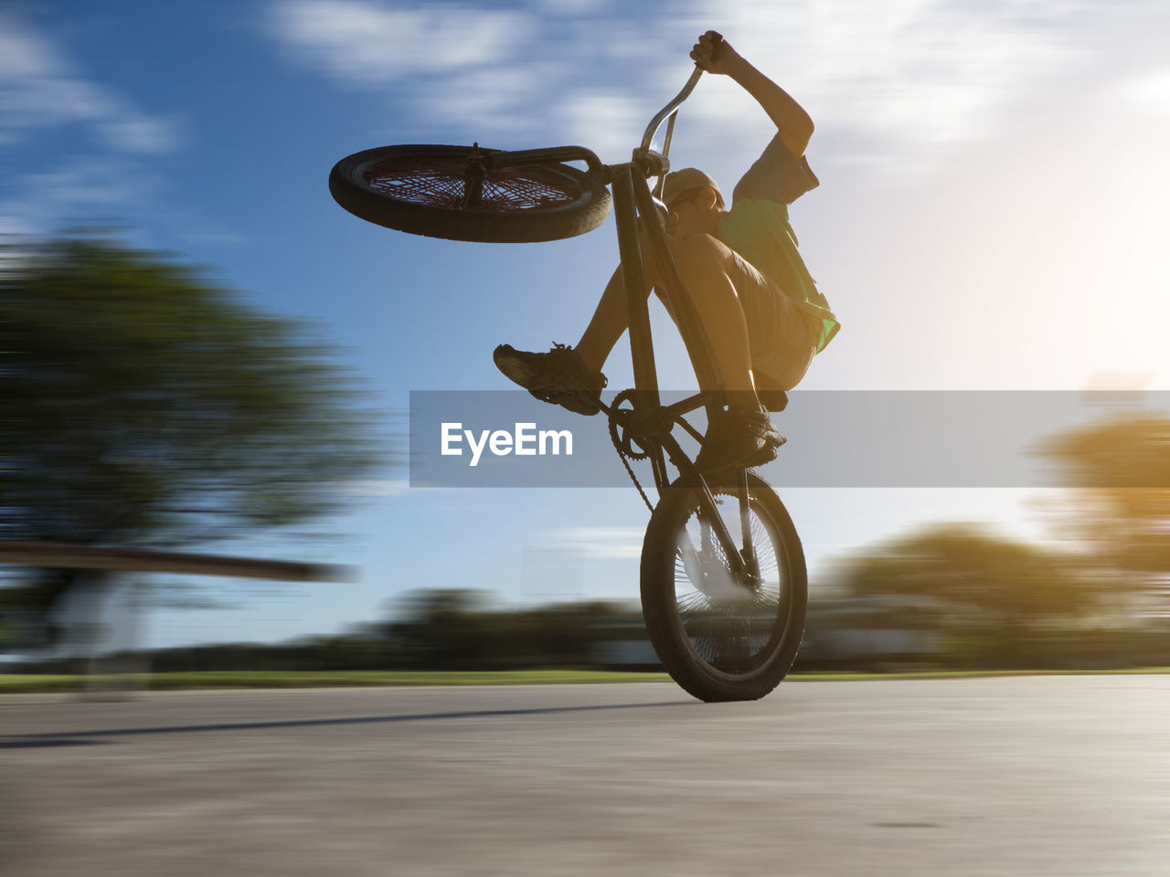 Man riding bicycle on road against sky