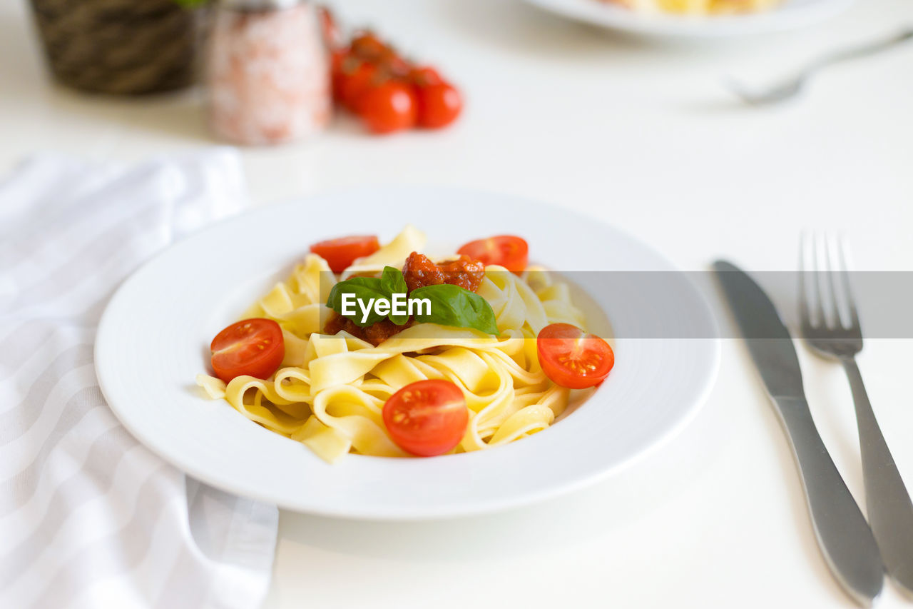 Fresh italian pasta with cherry tomatoes, cheese and basil. vegetarian spaghetti. healthy food.