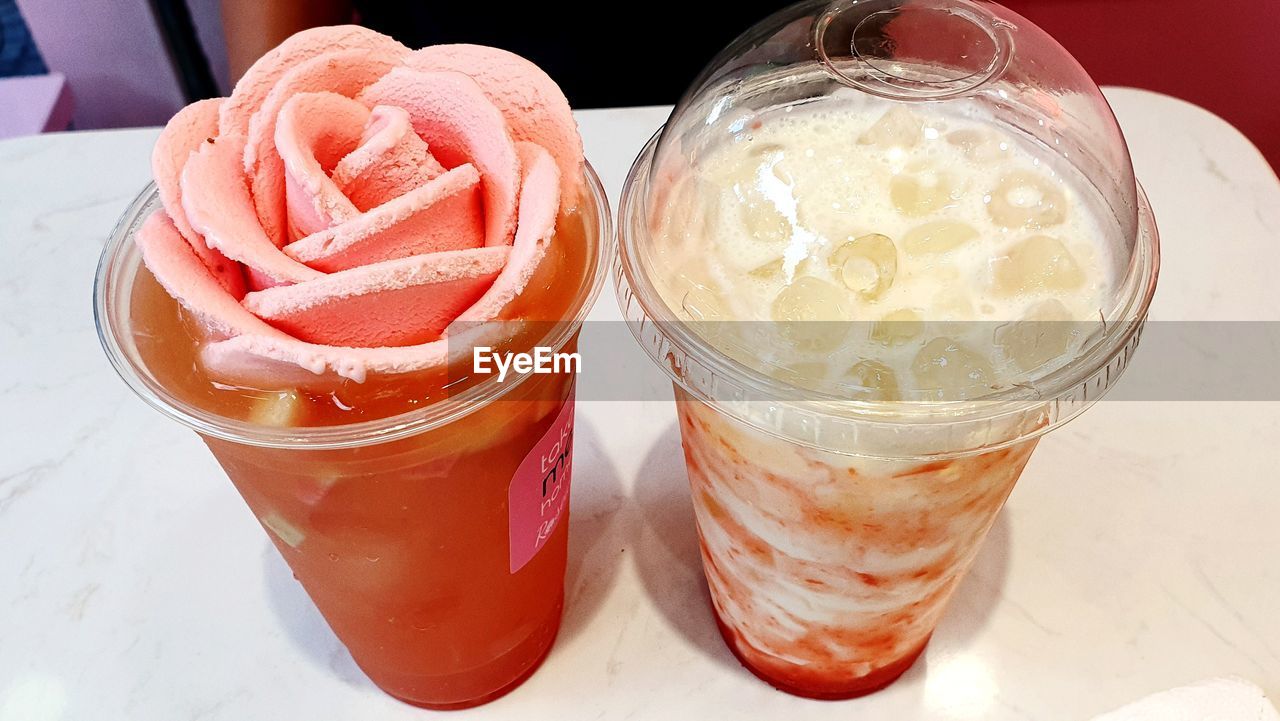 HIGH ANGLE VIEW OF ICE CREAM ON GLASS TABLE