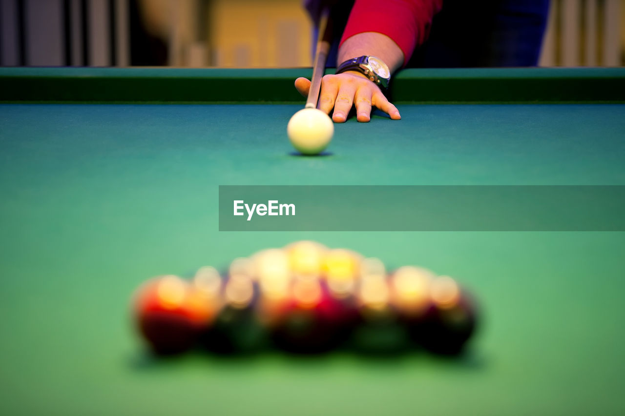 Cropped hand of man playing pool