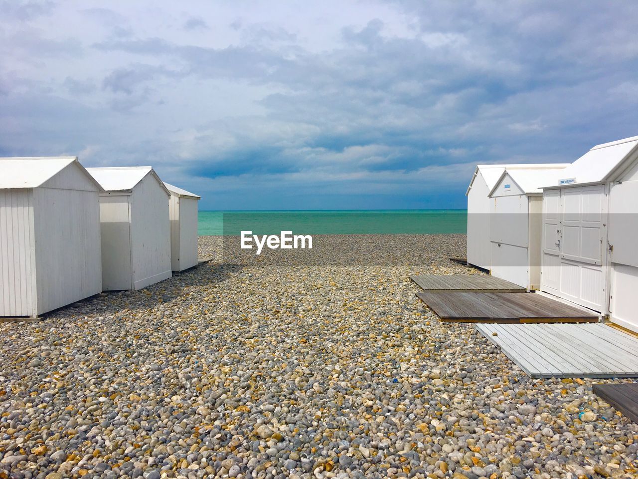 Beach huts by sea against sky