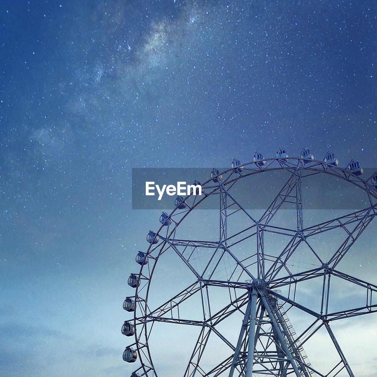 Low angle view of ferris wheel against sky at dusk