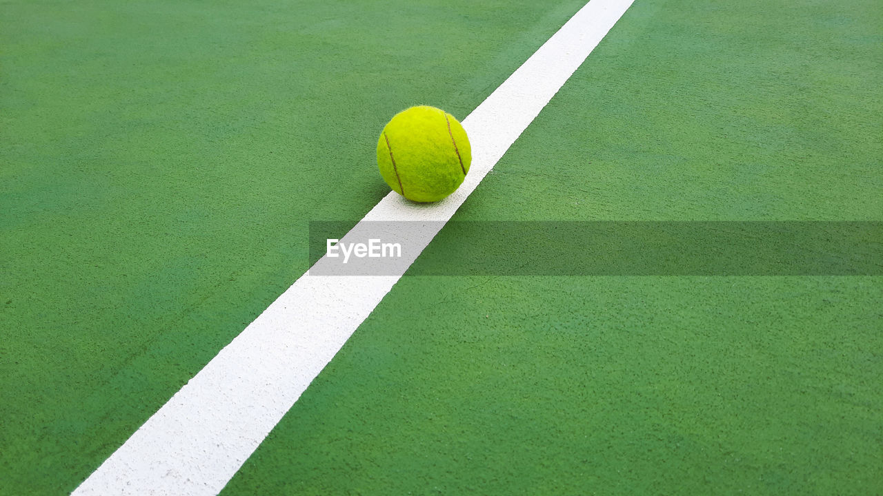 Tennis ball on a line of tennis court 