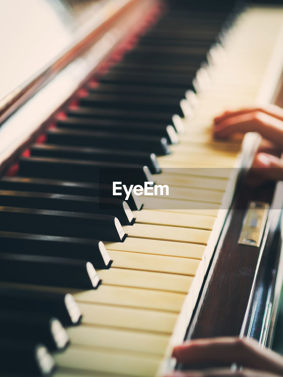 Close-up of hands playing piano in home