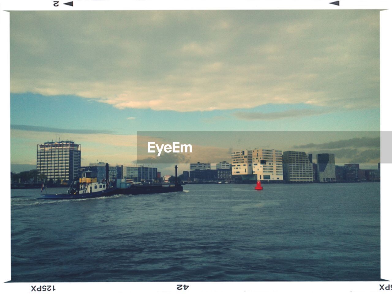 Boat sailing in sea with city in background