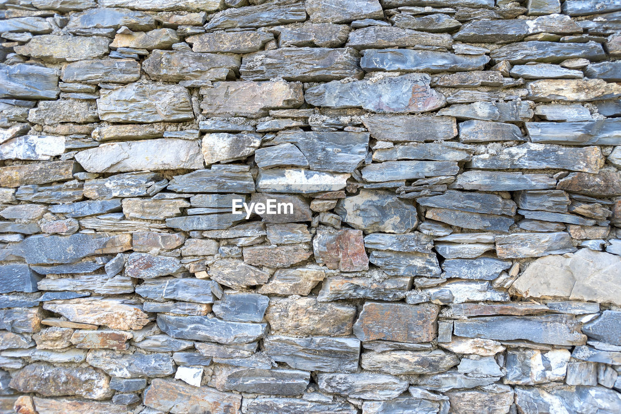 FULL FRAME SHOT OF STONE WALL WITH ROCKS