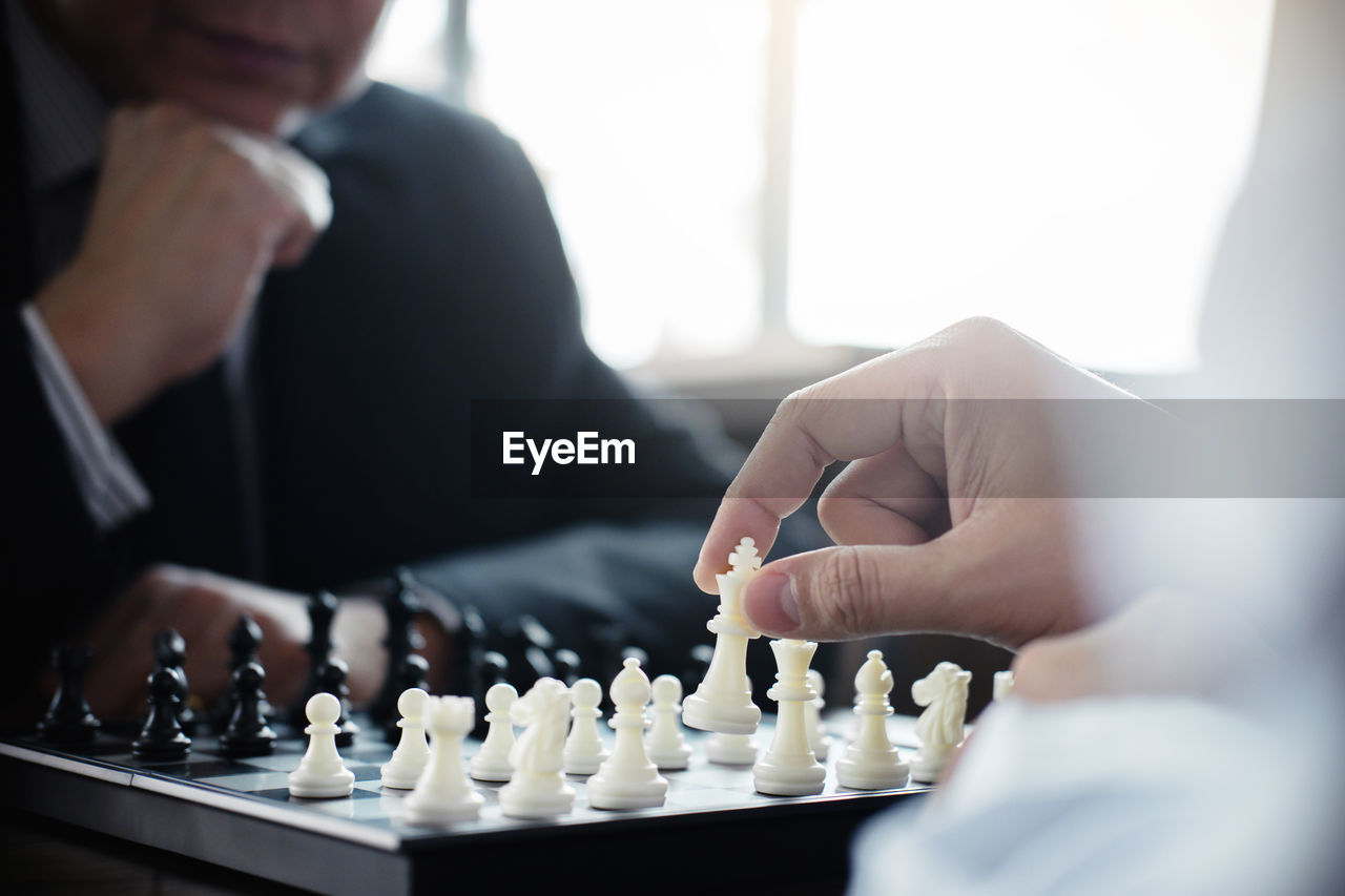 Midsection of businessmen playing chess