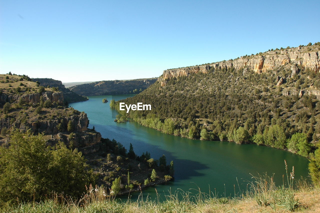 Scenic view of lake against clear blue sky