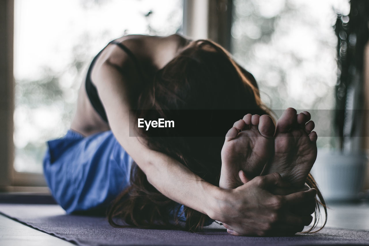 Woman doing yoga on floor at home