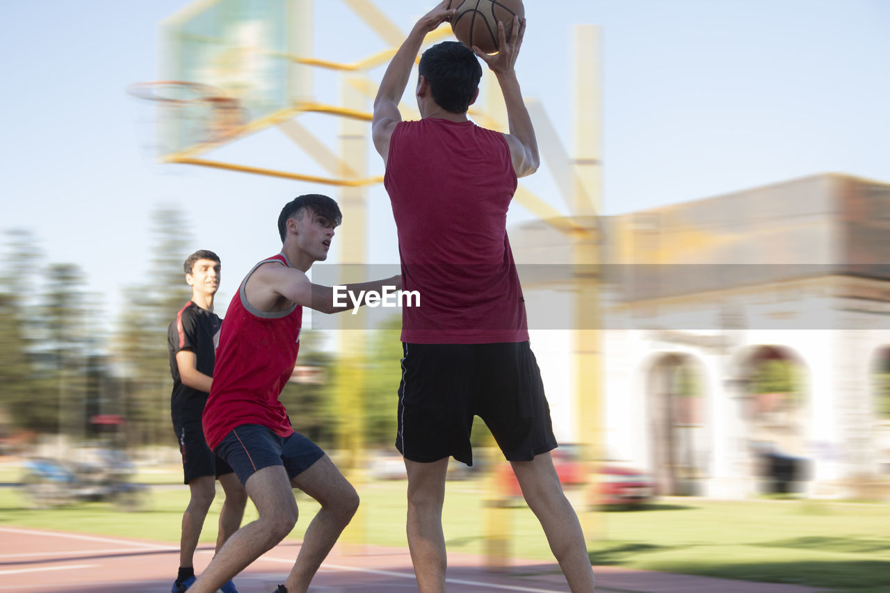 Teenagers playing street baskeball