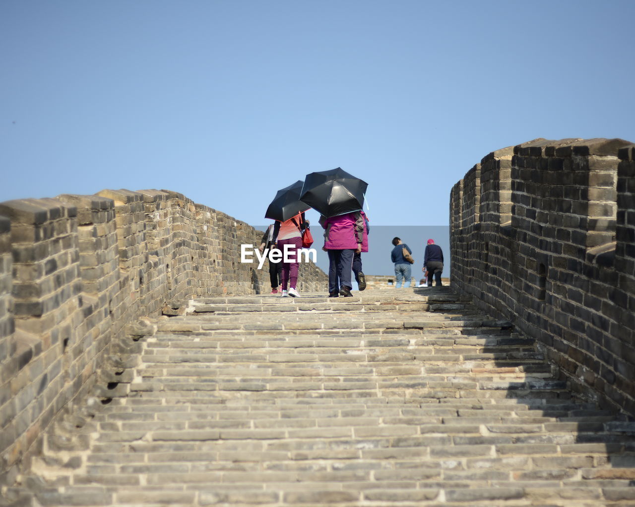 Tourist moving up on great wall of china against sky