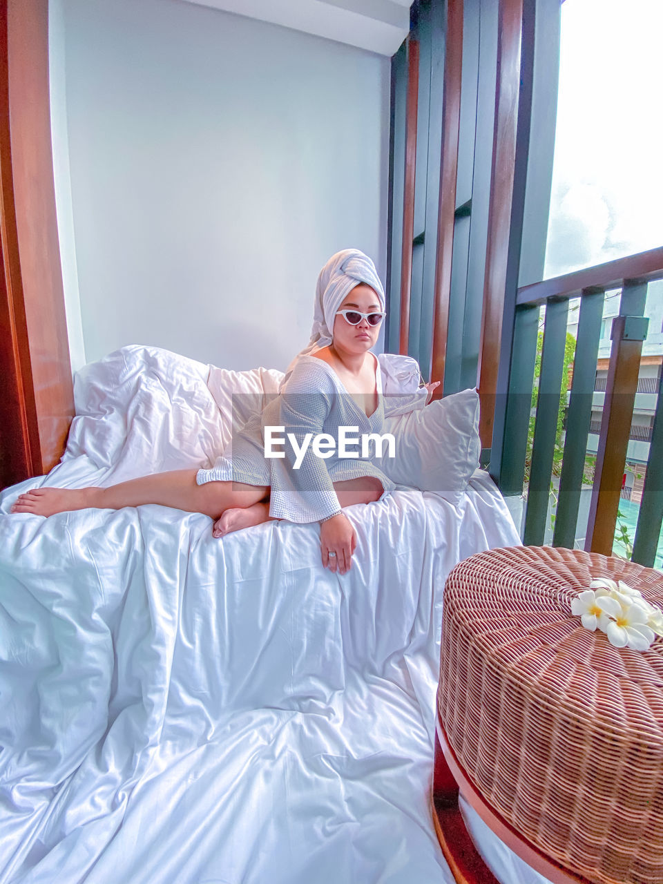 Full length of woman relaxing on bed at hotel