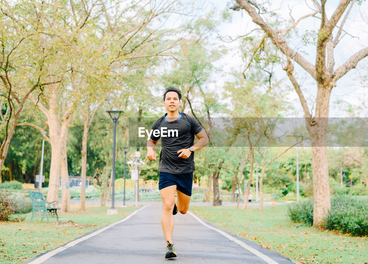 Full length of man running on footpath